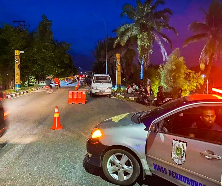 Petugas Dishub Pekanbaru mengatur arus lalu lintas saat proses perbaikan portal Jembatan Leton, Selasa (6/6/2023) malam. Foto: Istimewa.