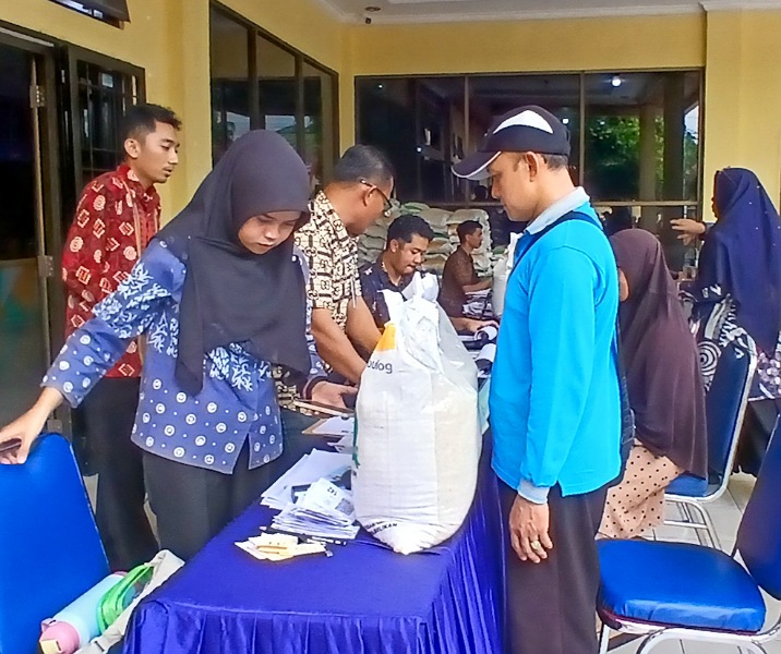 Warga menerima beras CPP di Kantor Kecamatan Limapuluh. Foto: Surya/Riau1.