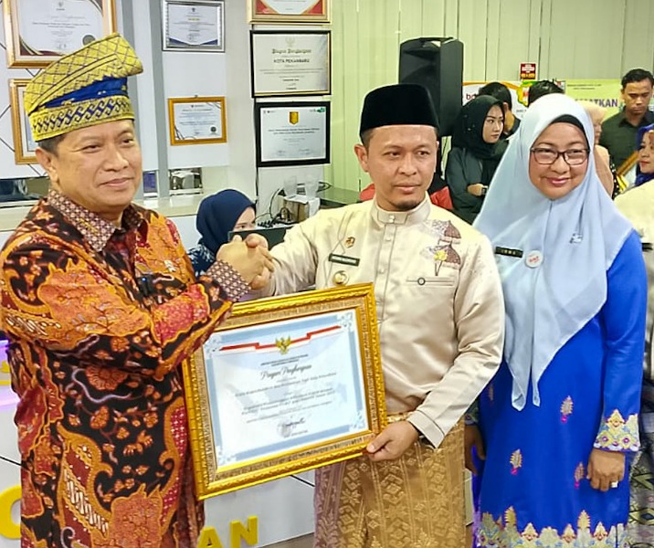 Kepala Disdukcapil Pekanbaru Irma Novrita mendampingi Wali Kota Agung Nugroho menerima piaham penghargaan Pelayanan Prima dari Wamenpan RB Purwadi Arianto, Kamis (7/8/2025). Foto: Istimewa.