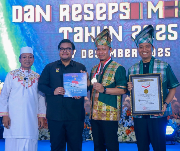 Wali Kota Pekanbaru Agung Nugroho didampingi Wawako Markarius Anwar dan Ustaz Das'ad Latif saat menerima penghargaan dari MURI dalam kategori tepuk tepung tawar terbanyak di acara Nikah Massal, Minggu (7/12/2025). Foto: Istimewa.