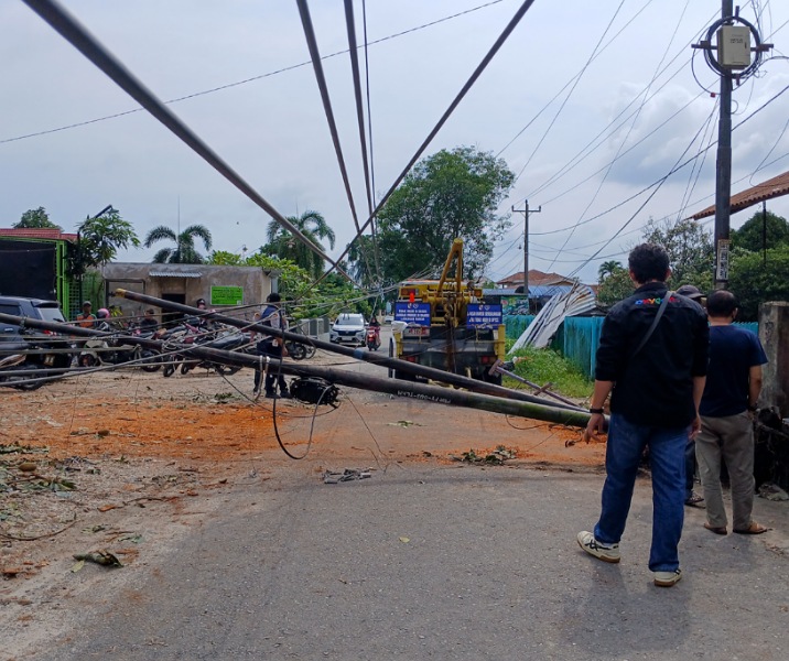 Tiang kabel fiber optik tumbang dan melintang di Jalan Rindang, Harapan Raya, Minggu (1/2/2026). Foto: Surya/Riau1.