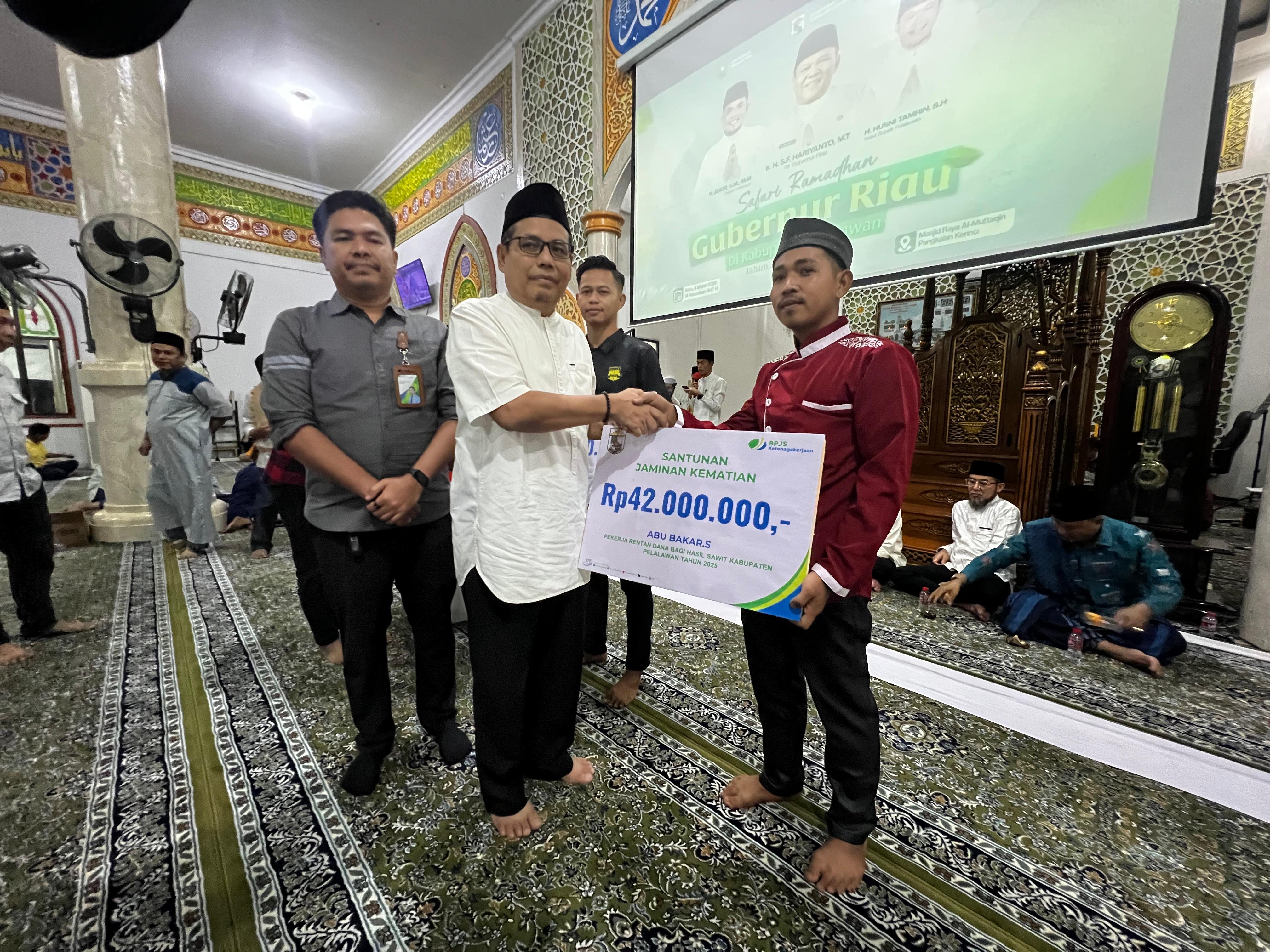 Asisten I Sekdaprov Riau bersama Kepala Cabang BPJS Ketenagakerjaan Pelalawan menyerahkan santunan secara simbolis