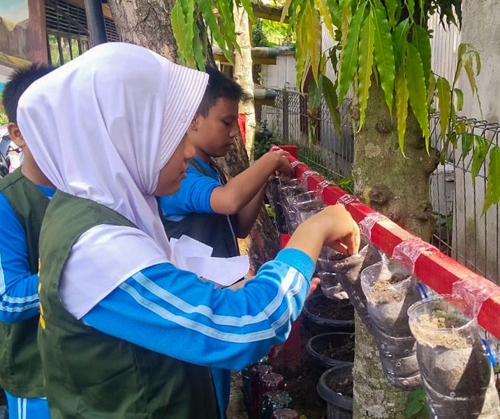 Murid SD Negeri 123 Pekanbaru menanam bibit tanaman. Foto: Istimewa.