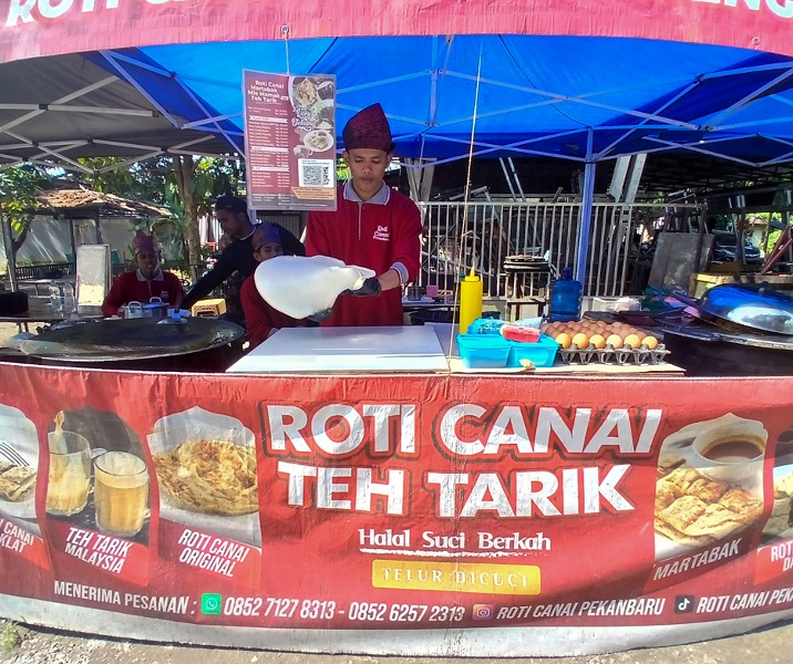 Seorang karyawan Roti Canai Pekanbaru sedang menipiskan adonan hingga tipis agar bisa diisi dengan berbagai potongan daging, sarden, hingga telur. Foto: Surya/Riau1.
