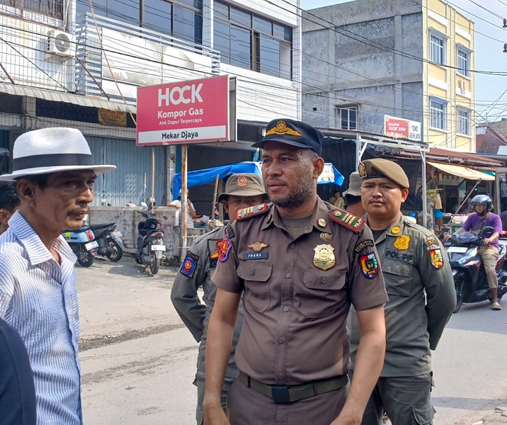 Petugas Satpol PP Pekanbaru memberi peringatab terakhir kepada para pedagang di Jalan Teratai agar segera pindah karena akan ada pekerjaan perbaikan jalan. Foto: Surya/Riau1.