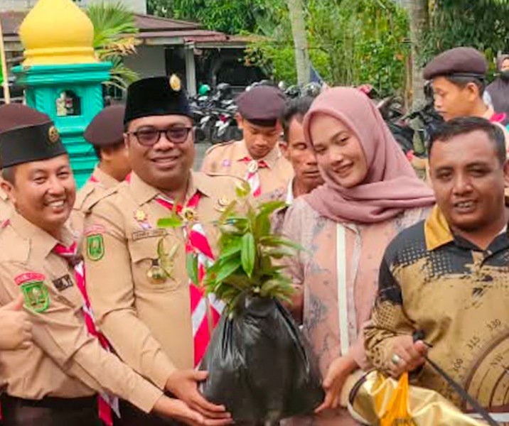 Wakil Ketua Kwarcab Pekanbaru Bidang Abdimasgana dan LH Zarman Candra saat menyerahkan bibit pohon ke warga. Foto: Istimewa.